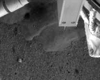 Phoenix Lander Robotic Camera Sees Possible Ice